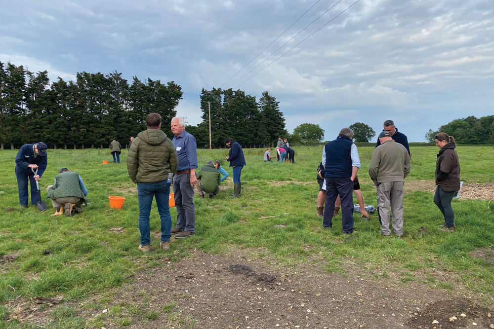 Farmers practicing methods to measure soil porosity and compaction